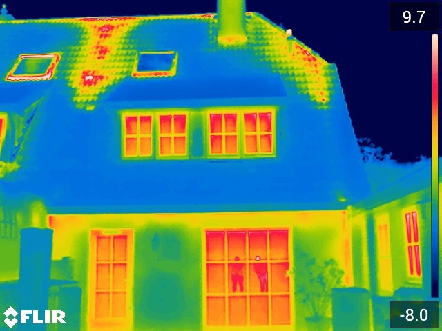 Een warmtescanfoto van een huis waarbij rood warmtelekken aantoont